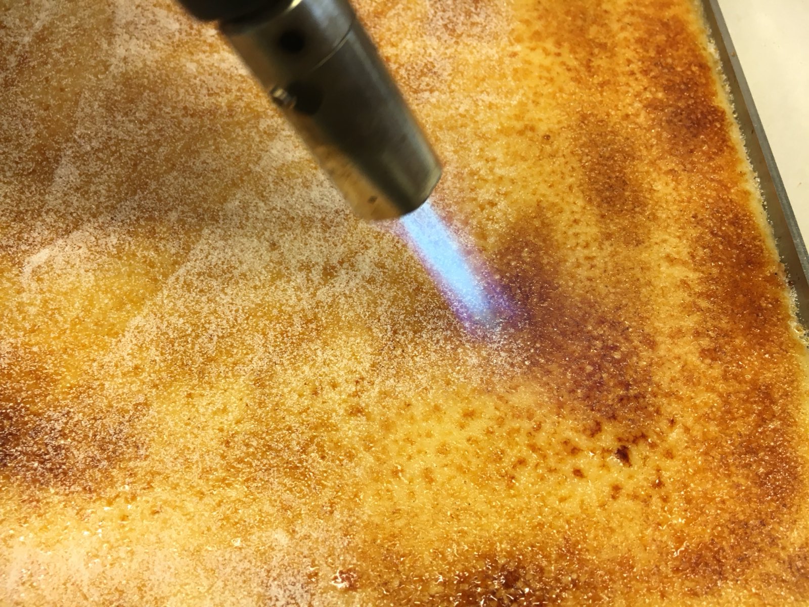 Met de brander wordt suiker gekaramelliseerd in het atelier