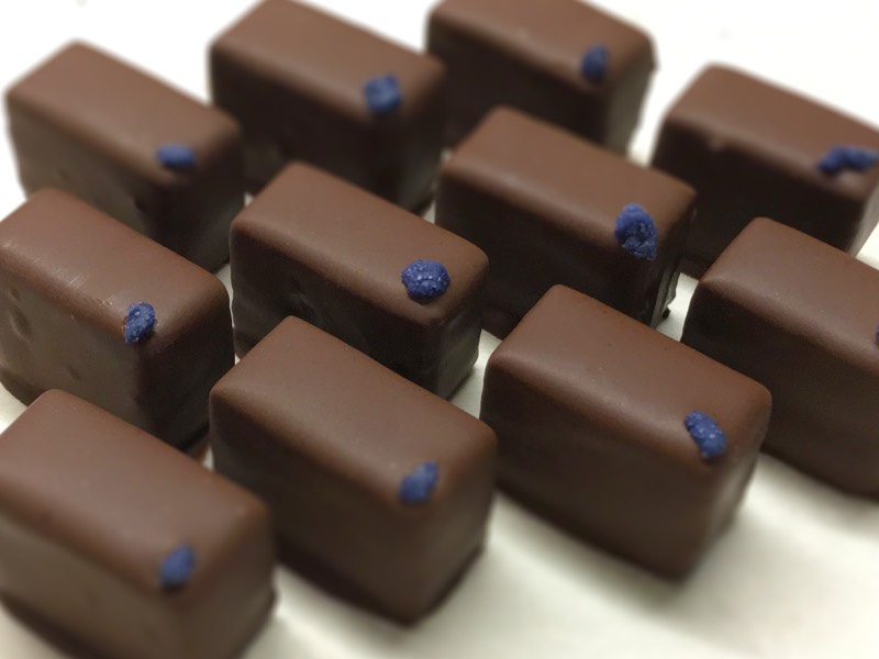 Bonbons met zwarte bessen met viooltjes en gekaramelliseerde witte chocola