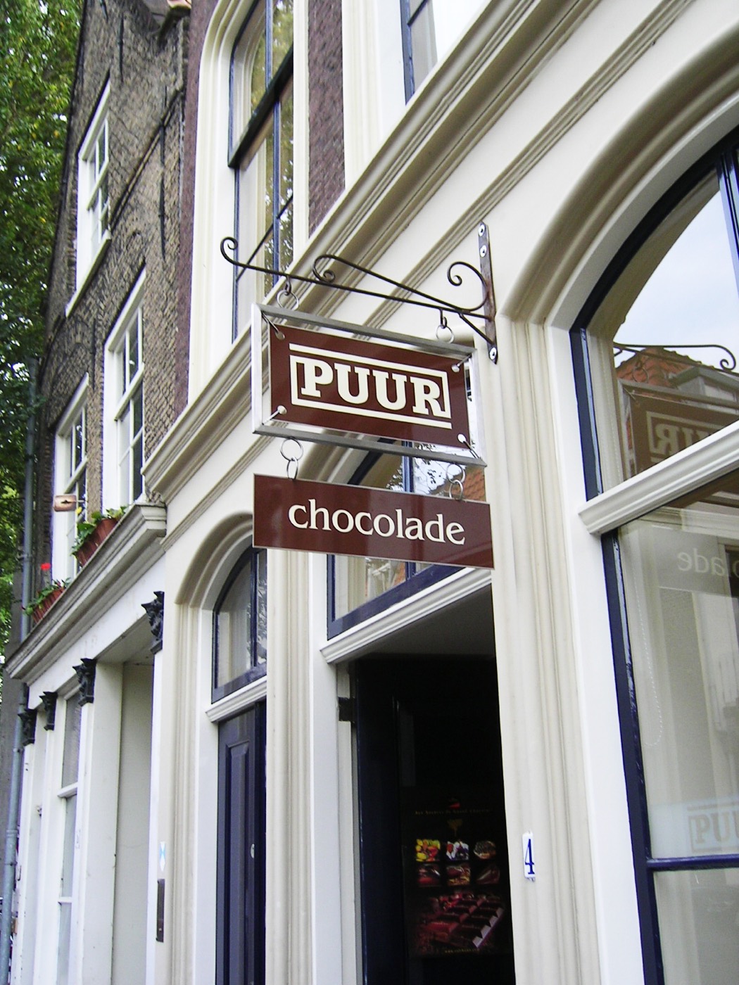 Het uithangbord met PUUR chocolade aan de gevel