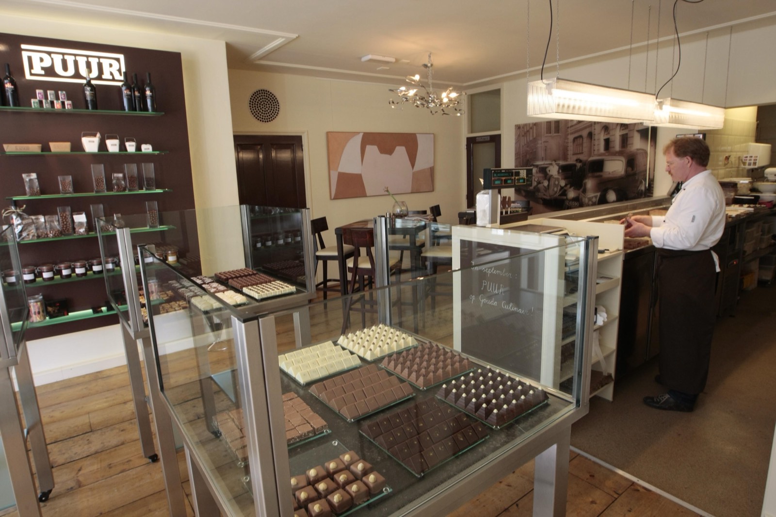 De vitrine met bonbons in de winkel, met op de achtergrond het atelier